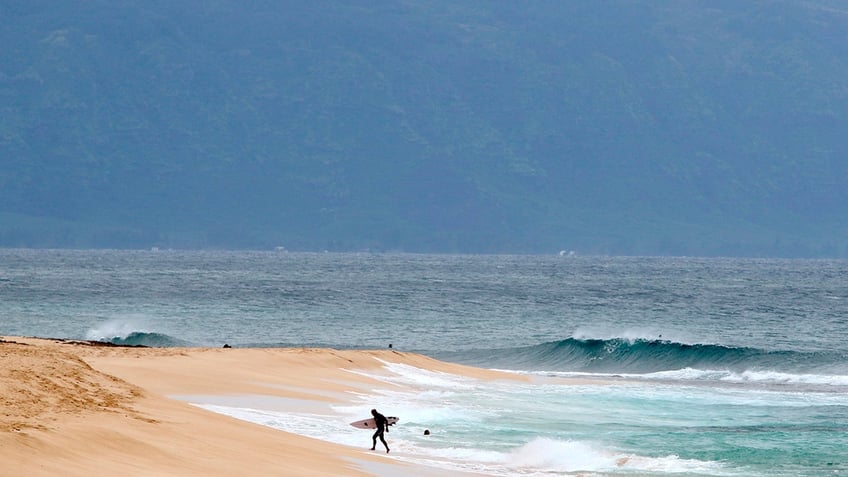 surfer walks out of the ocean