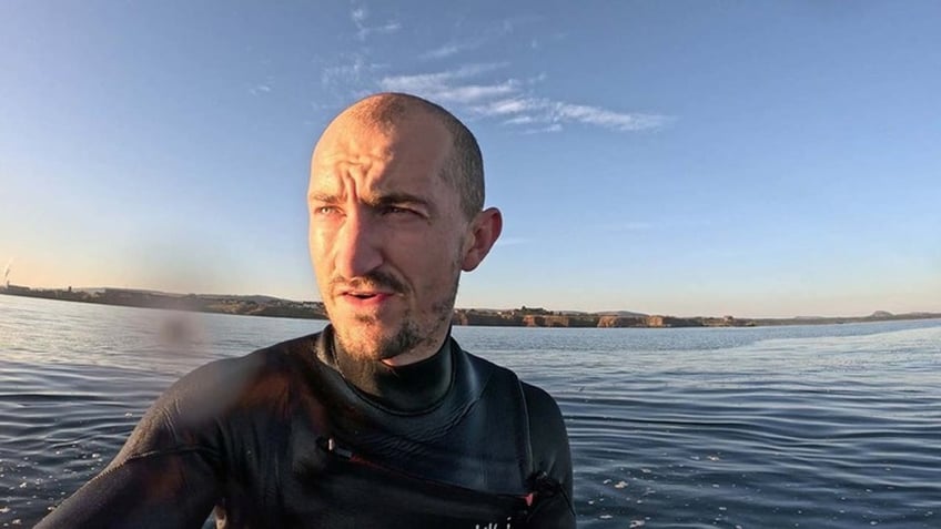 shark with massive jaw circles nervous paddleboarder in eerie footage