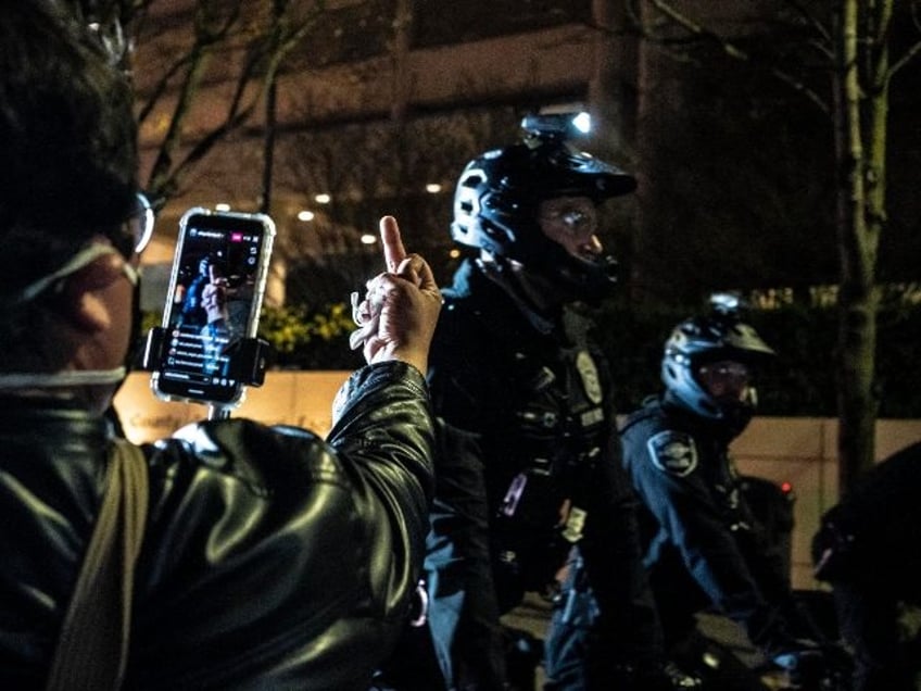 SEATTLE, WA - APRIL 12: (EDITORS NOTE: Image depicts obscene gesture) A person records pol