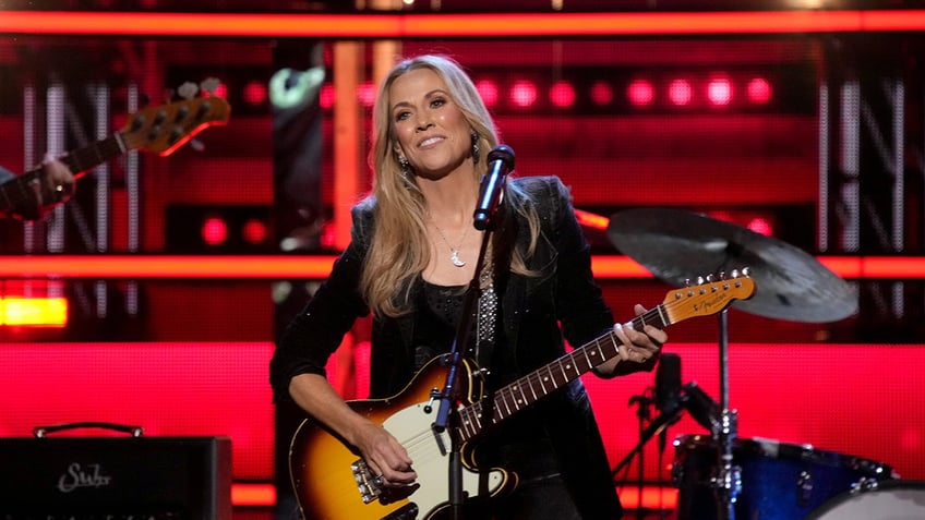 Sheryl Crow performing on stage with guitar