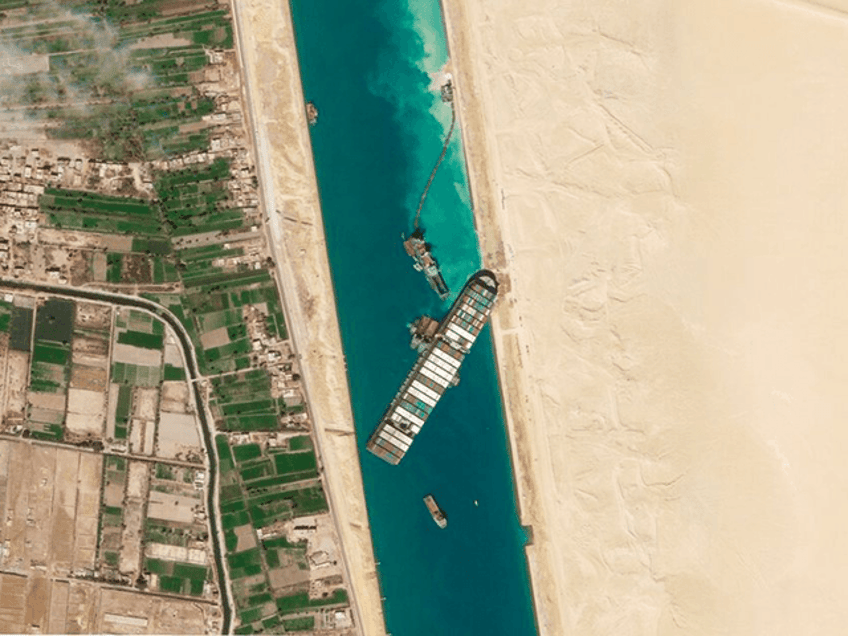 In this March 28, 2021, satellite file image from Planet Labs Inc, the cargo ship MV Ever Given sits stuck in the Suez Canal near Suez, Egypt. Consumers may face shortages and higher prices for electronics, toys, furniture and other goods should attempts to free the mammoth container ship stuck in Egypt’s Suez Canal drag on several weeks. (Planet Labs Inc. via AP)