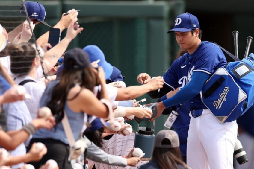 Los Angeles Dodgers designated hitter Shohei Ohtani signs autographs for supporters before