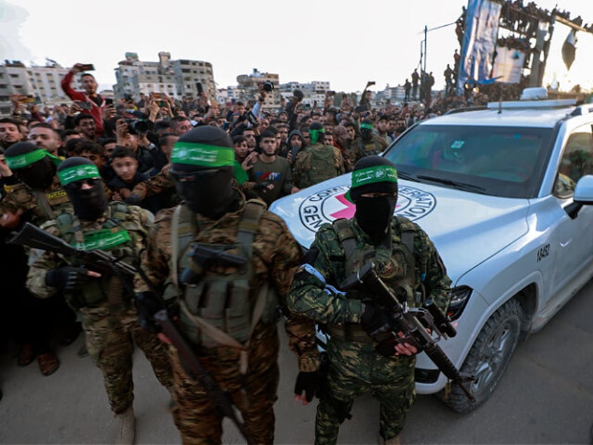 Hamas fighters escort a Red Cross vehicle to collect Israeli hostages released after a cea