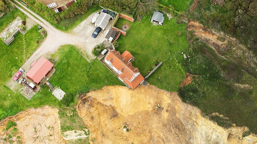 farmhouse hanging over cliff edge SWNS
