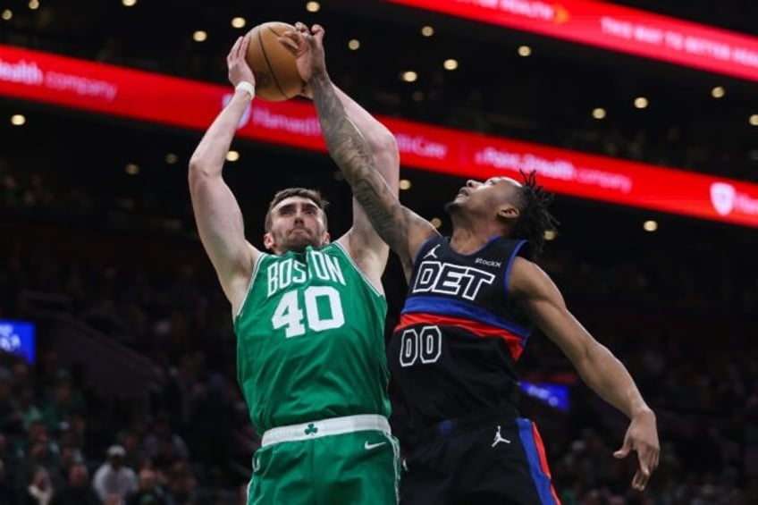 Luke Kornet of the Boston Celtics battles for the ball with Ronald Holland II of Detroit i