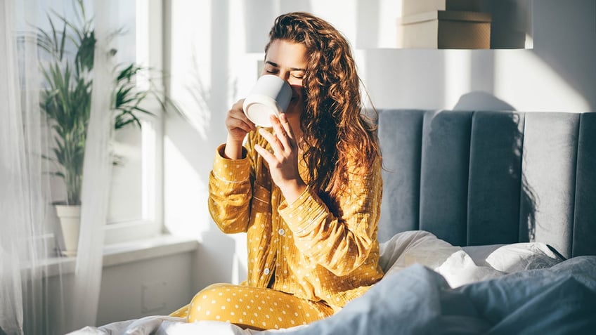 woman drinking coffee in bed