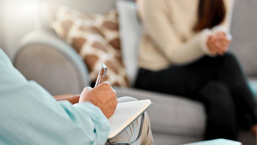 Cropped shot of a psychologist making notes during a consultation