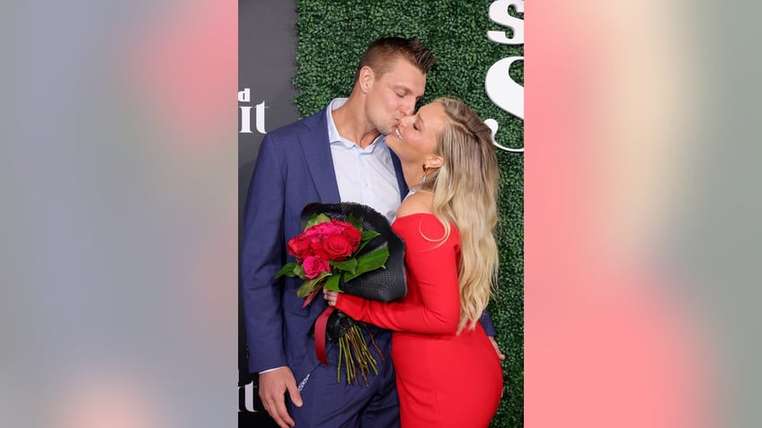 Gronk kissing Camille Kostek on the cheek