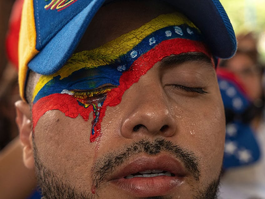 A Venezuelan national attends a rally to denounce what the community says are fraudulent r