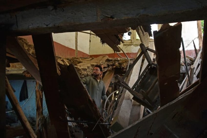 A man in Jura village in the Neelum Valley inspects his damaged home after the latest Indi