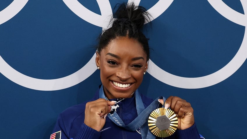 Simone Biles poses with a gold medal