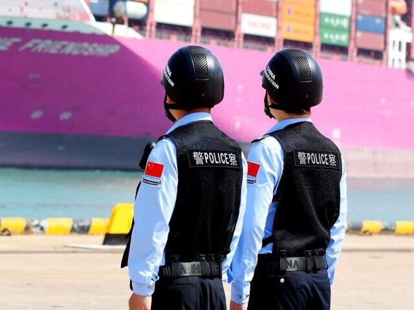 Police officers at Huangdao border inspection Station wait for a cargo ship to dock at the