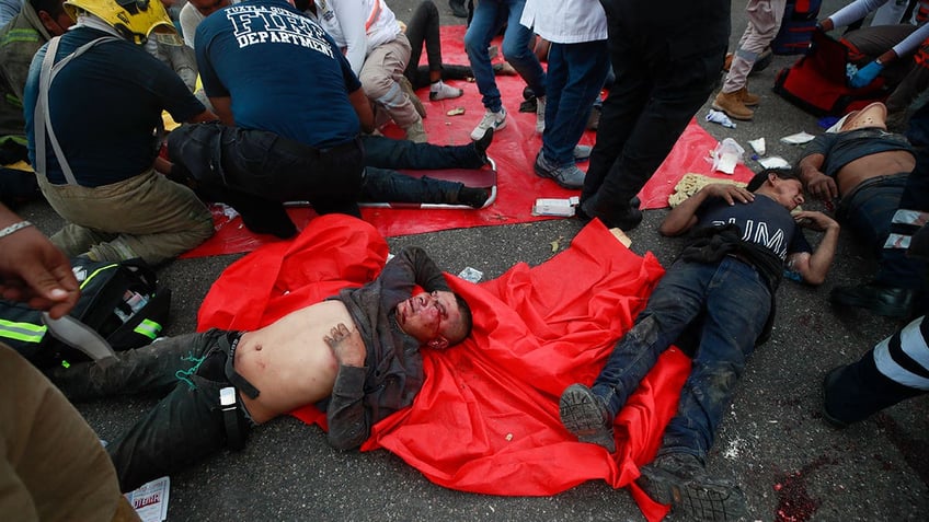 Injured migrants are cared for on the side of the road after an accident near Tuxtla Gutierrez, Mexico, Dec. 9, 2021.