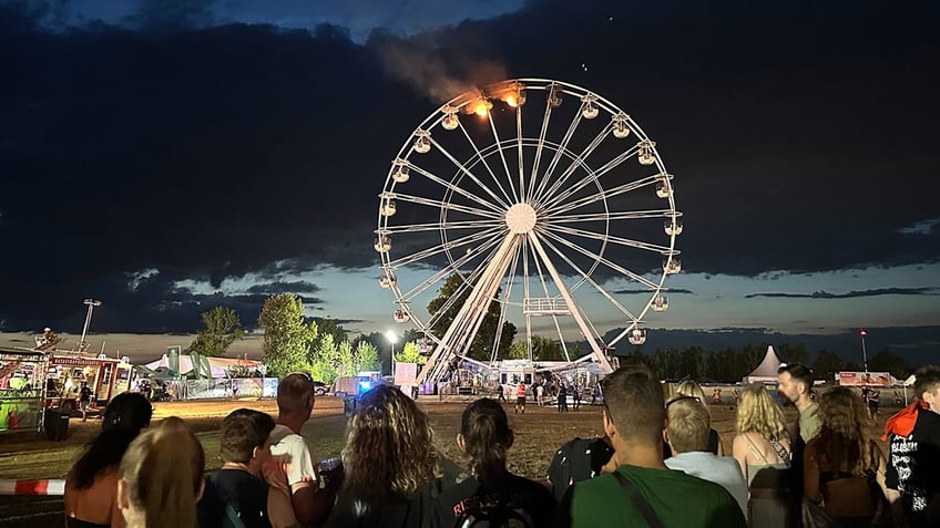 Onlookers watch as Ferris wheel continued to burn