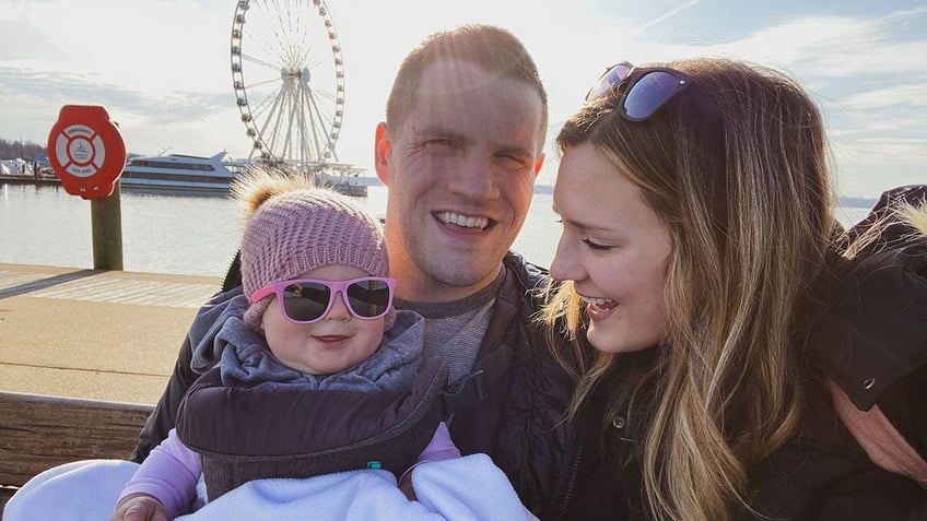 Jared, Kirsten and Bexley Bridegan pose in front of a ferris wheel.