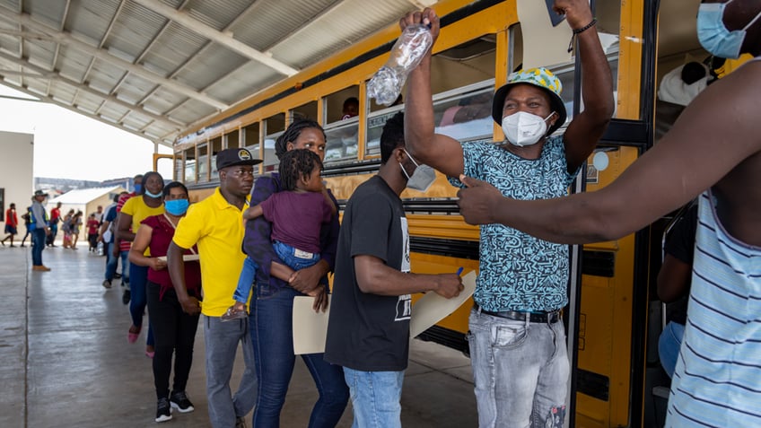 Migrants boarding bus