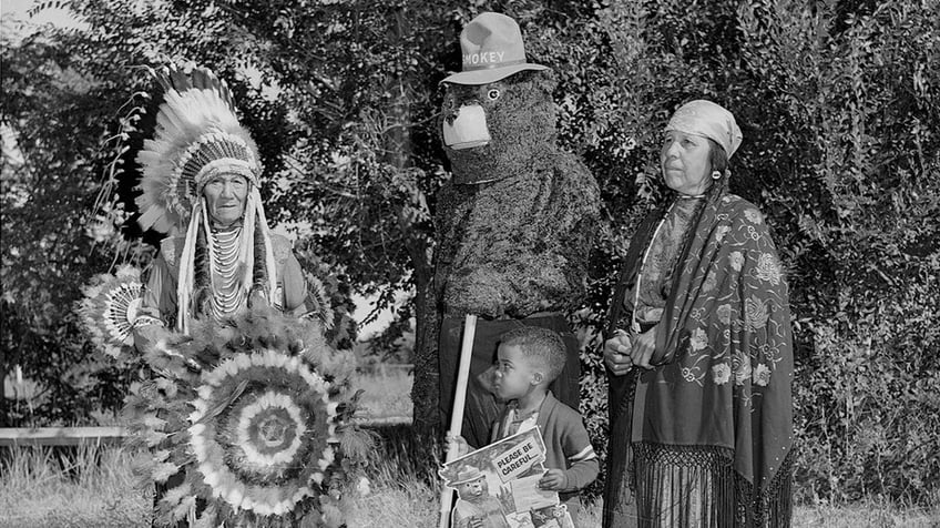 Smokey the Bear, Flathead (Salish) chief Paul Charlo, his wife, and young Allen Thompson pose.