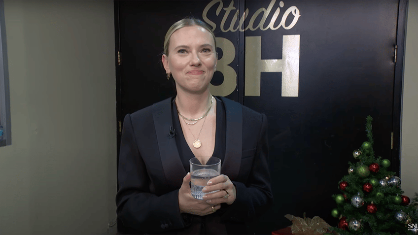 Scarlett Johansson clutches her drink as she stares at the camera backstage at "SNL"