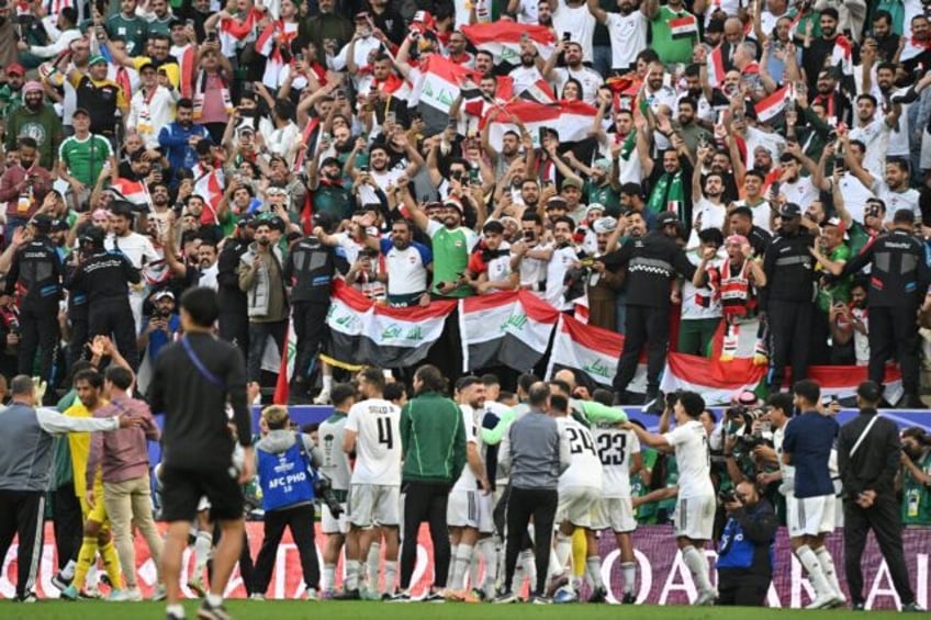 Iraq players celebrate with their fans after beating Japan at the Asian Cup in Doha