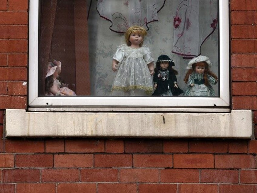 Dolls are displayed in an upper floor window of a house in the Eastwood area of Rotherham,