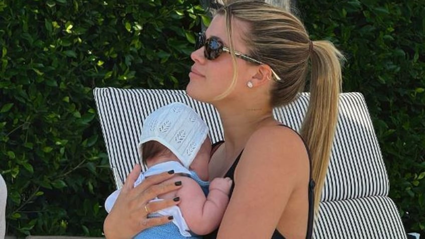 Sofia Richie holding her baby