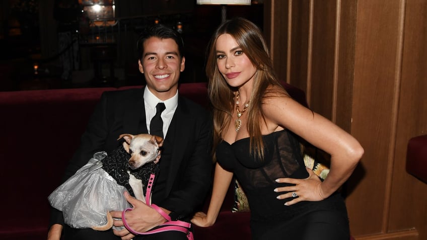 sofia vergara sitting on a couch with her son manolo and their dog