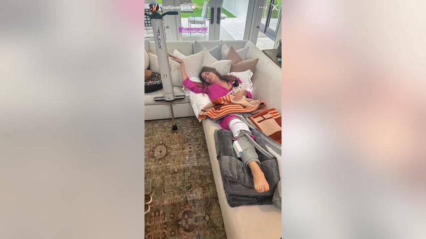 sofia vergara laying on couch with knee brace