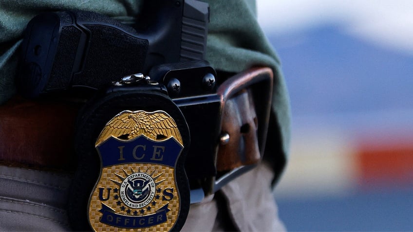 ICE officer with badge and gun