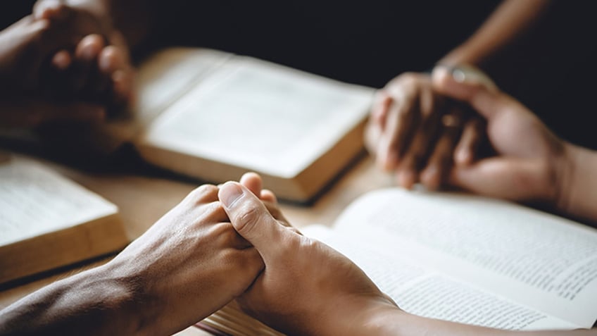 A group praying and holding hands.