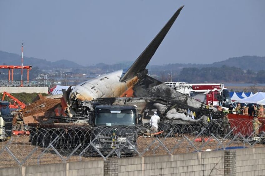 Rescue personnel work near the wreckage of a Jeju Air plane after it crashed at South Kore