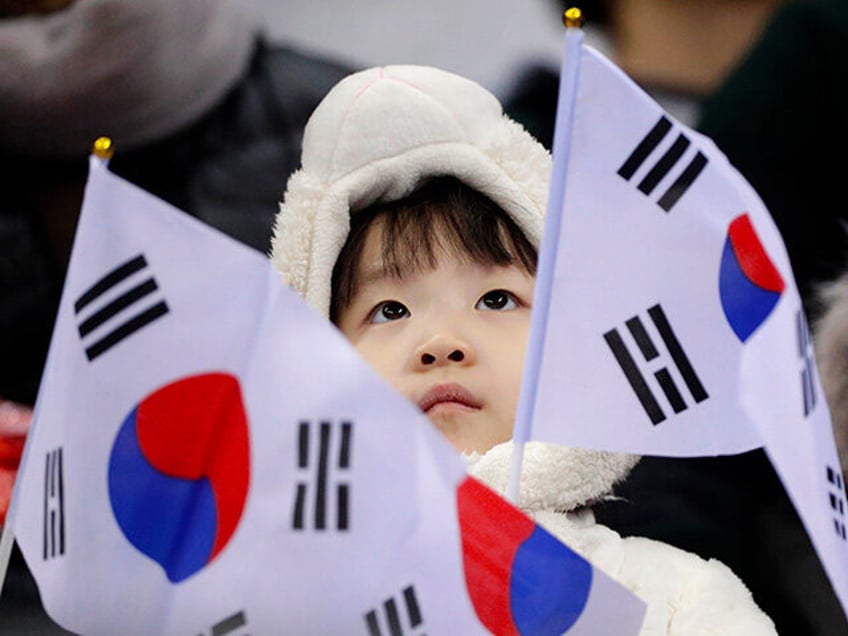 A South Korean fan waves a flag during the ladies' 500 meters short track speedskating quarterfinal in the Gangneung Ice Arena at the 2018 Winter Olympics in Gangneung, South Korea, Tuesday, Feb. 13, 2018. (AP Photo/David J. Phillip)