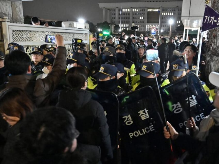 Police stand guard in front of the main gate of the National Assembly in Seoul on December