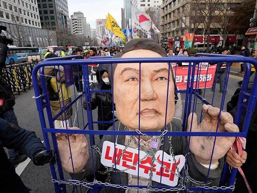 Protesters carry a caricature depicting an imprisoned South Korean President Yoon Suk Yeol