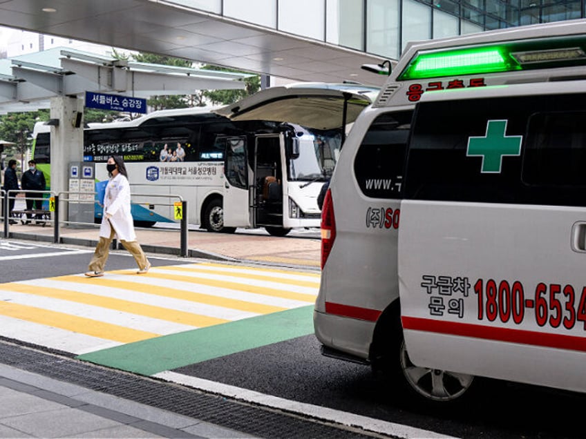 A medical worker walk past an ambulance parked outside The Catholic University of Korea Se