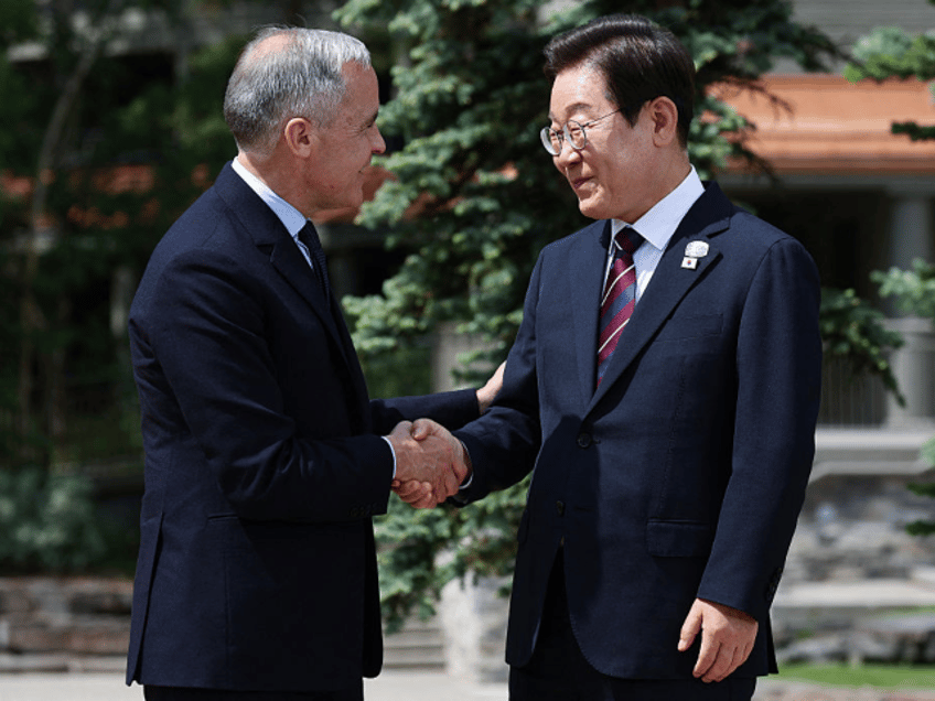 Canadian Prime Minister Mark Carney (L) greets South Korean President Lee Jae-myung before