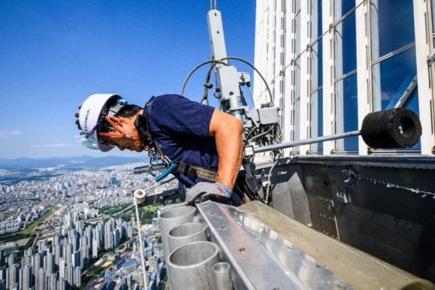Seo Seung-ho looks down from a special gondola at the Lotte World Tower