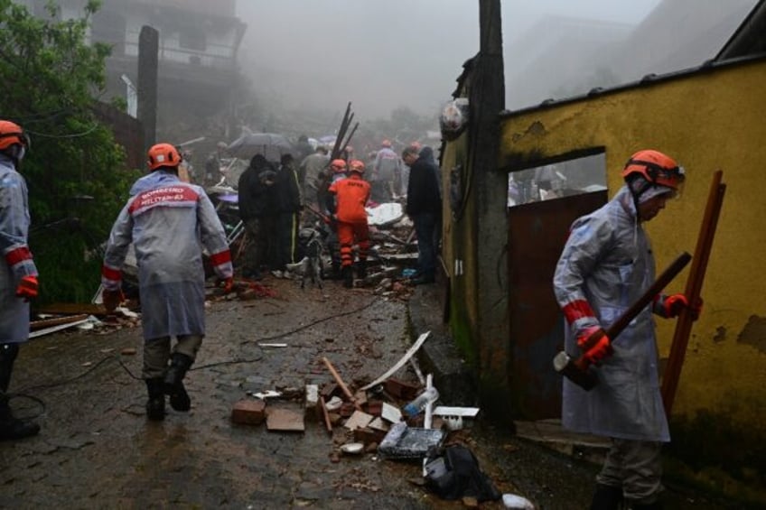 Members of the Civil Defense, firefighters and local residents work to rescue victims of h