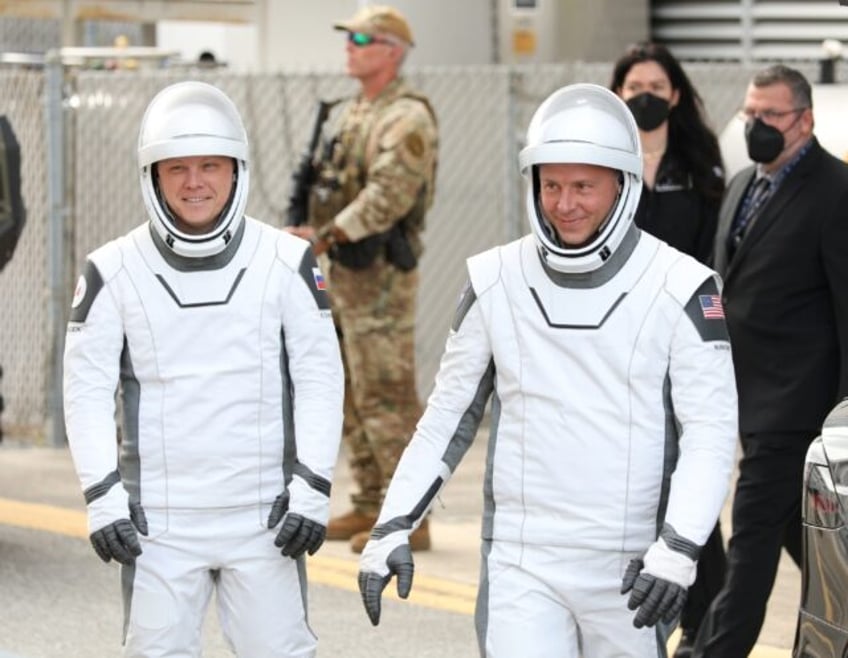 US astronaut Nick Hague (R) and Russian cosmonaut Alexander Gorbunov head to a Kennedy Spa