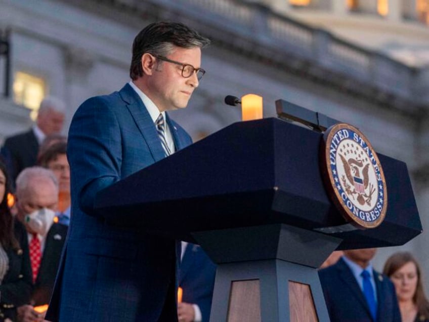 House Speaker Mike Johnson of La., pauses in prayer as members of Congress hold a candleli