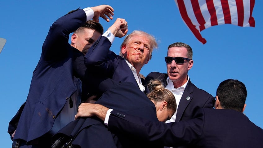 Republican presidential candidate former President Donald Trump is surrounded by U.S. Secret Service agents at a campaign rally