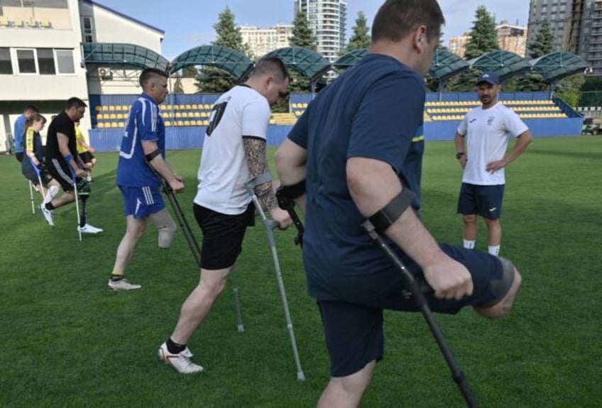 Coach Dmytro Rzhondkovskyi (R) prepares Ukraine's amputee football squad for the Euro 2024