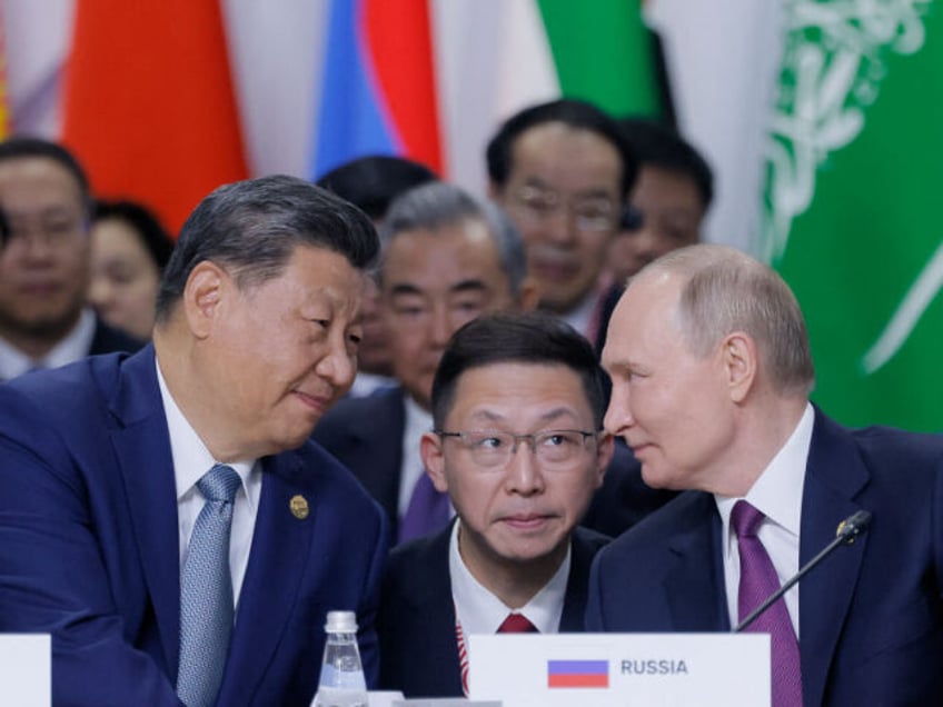 Russian President Vladimir Putin and Chinese President Xi Jinping speak during a plenary s
