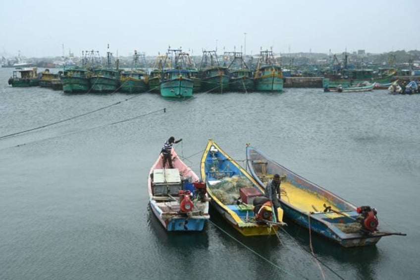 Fishermen prepare to dock their boats as part of a preventive measure from a predicted cyc