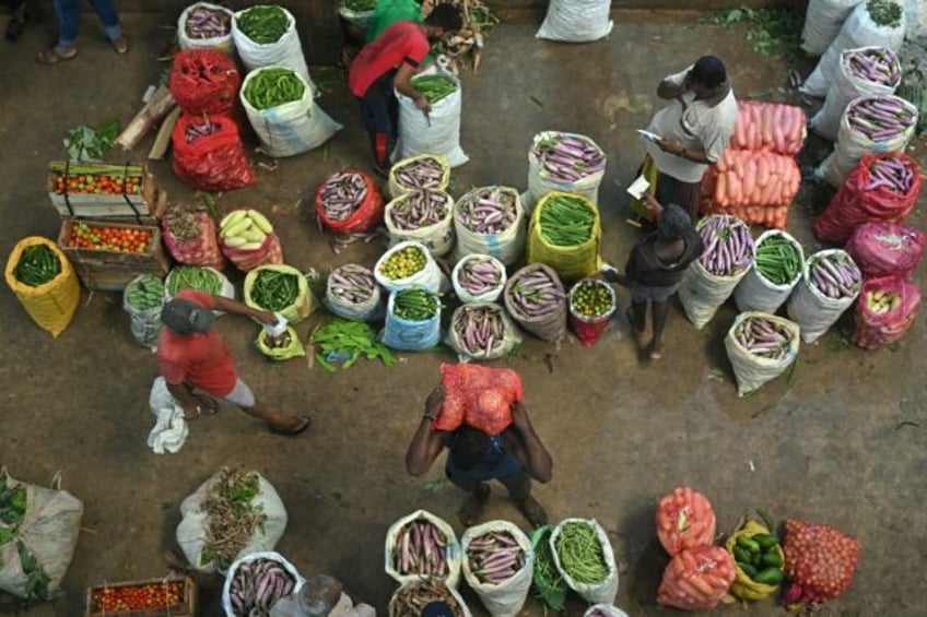 Traders at a vegetable market in Colombo; the World Bank says the island's 2022 economic c