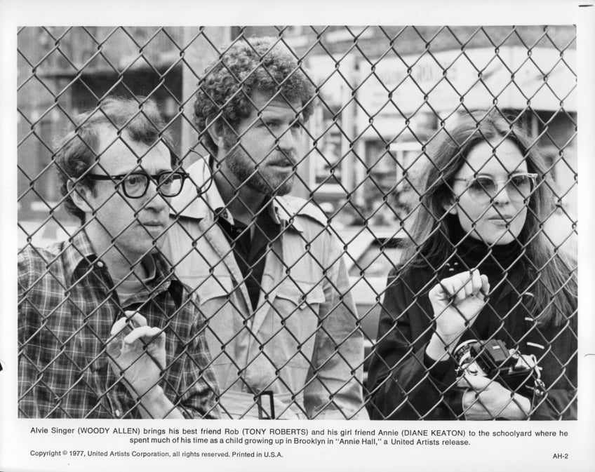 Woody Allen, Tony Roberts and Diane Keaton standing behind a chain link fence in a scene from the film 'Annie Hall', 1977. (Photo by United Artists/Getty Images)