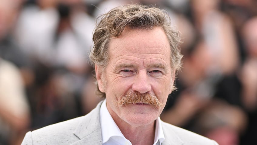 Bryan Cranston in a light grey suit with a bushy mustache at Cannes film festival