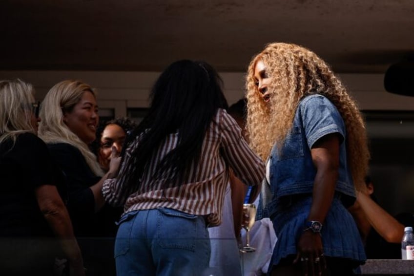 Retired tennis great Serena Williams (R) mingles in the stands of Arthur Ashe Stadium at t