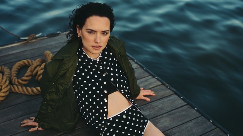 Actress daisy Ridley sports polka dot cardigan and matching bottoms on a lake.