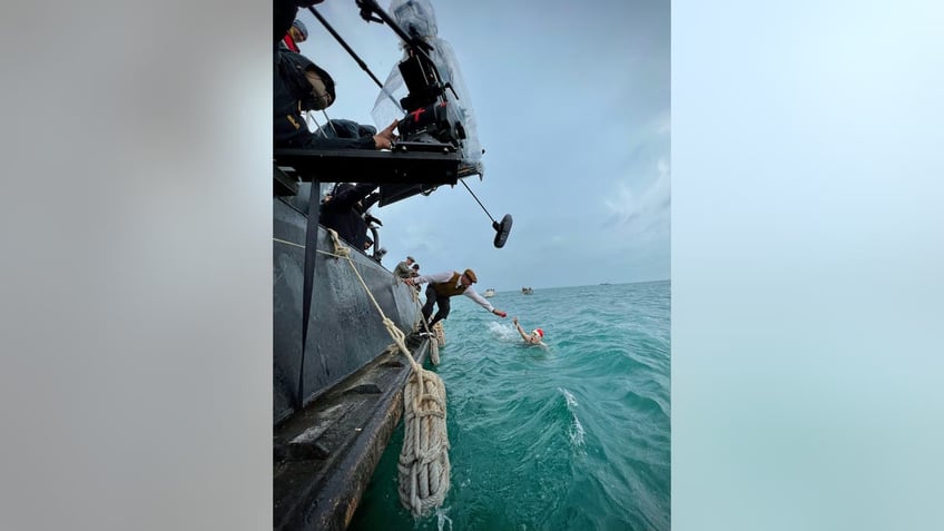 Behind the scenes photo of Daisy Ridley swimming in "Young Woman and the Sea"