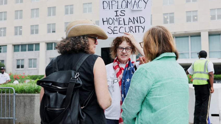 Protesters gather outside the State Department building